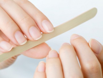 A woman uses a nail file. A woman uses a nail file.