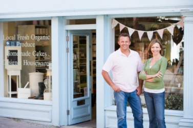 A couple stand outside their nascent business. A couple stand outside their nascent business.