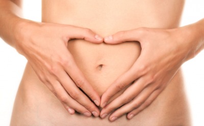 A woman frames her navel with her hands. A woman frames her navel with her hands.