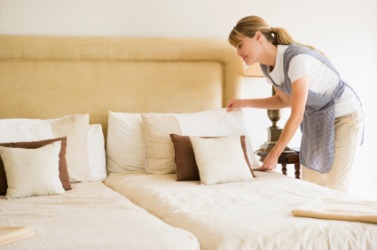 A maid makes sure this hotel room is neat. A maid makes sure this hotel room is neat.