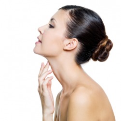 A woman touching her neck. A woman touching her neck.