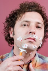 This man has nicked himself while shaving. This man has nicked himself while shaving.