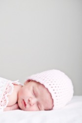 A newborn wearing a nightcap. A newborn wearing a nightcap.
