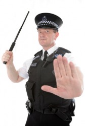 A policeman holds a nightstick. A policeman holds a nightstick.
