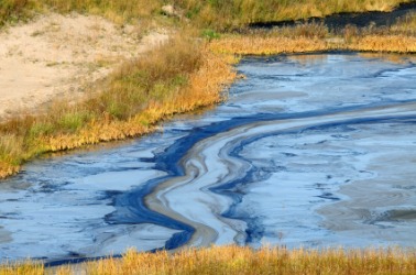 An oil slick reaches the shore. An oil slick reaches the shore.