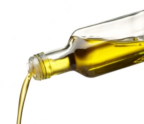 Olive oil being poured from a bottle. Olive oil being poured from a bottle.