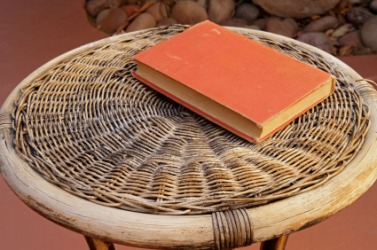A book sits on this wicker table. A book sits on this wicker table.