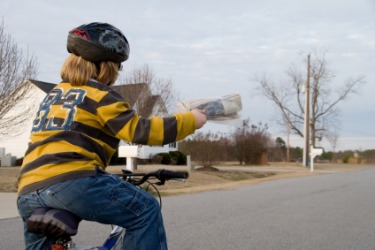 A paperboy delivering newspapers. A paperboy delivering newspapers.