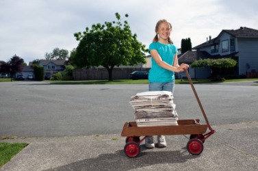 A papergirl delivering her newspapers. A papergirl delivering her newspapers.