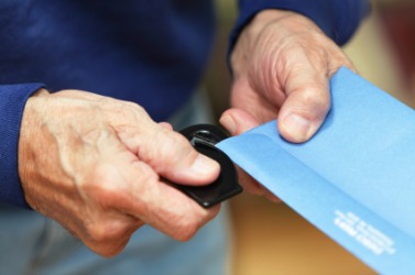 A man using a paper knife to open an envelope. A man using a paper knife to open an envelope.