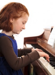 A little girl practicing the piano. A little girl practicing the piano.