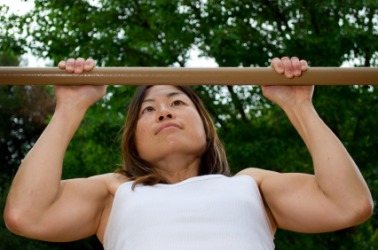 A woman performing a chin-up or pull-up exercise. A woman performing a chin-up or pull-up exercise.