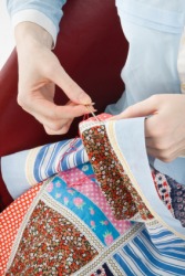 A woman engaged in quilting. A woman engaged in quilting.