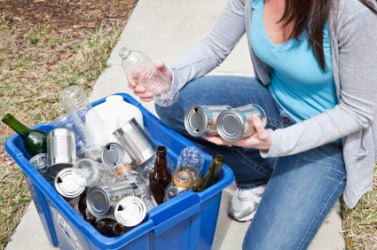 A woman recycles her glass and cans. A woman recycles her glass and cans.