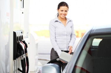 A woman refueling her car. A woman refueling her car.