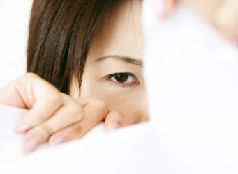 A woman rips a peice of paper. A woman rips a peice of paper.