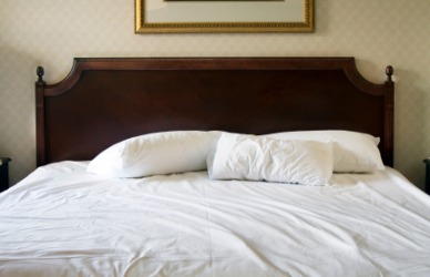 A bed covered with white sheets. A bed covered with white sheets.