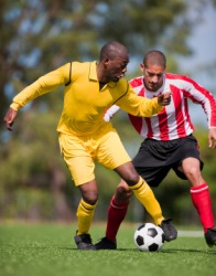 Two men playing a sport called soccer. Two men playing a sport called soccer.