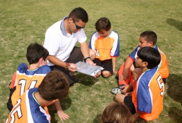 A coach discusses strategy with his team. A coach discusses strategy with his team.