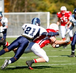 One football player tackles another. One football player tackles another.