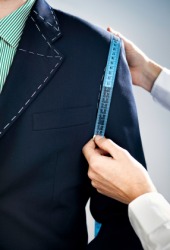 A tailor making a man's suit. A tailor making a man's suit.