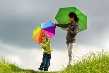 A mother and daughter each carrying an umbrella. A mother and daughter each carrying an umbrella.