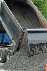 A dump truck unloads gravel. A dump truck unloads gravel.