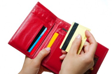 A person putting a credit card in their wallet. A person putting a credit card in their wallet.