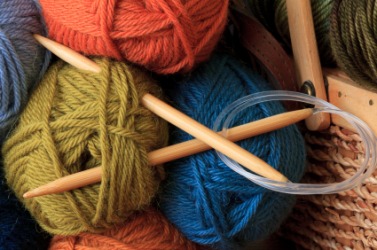 Knitting needles tucked into balls of yarn. Knitting needles tucked into balls of yarn.