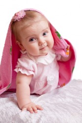 A baby looks out from beneath a blanket. A baby looks out from beneath a blanket.