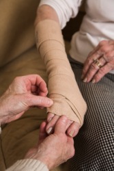 A woman wears an ace bandage on her arm. A woman wears an ace bandage on her arm.