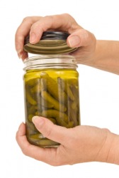 A person tries to remove a lid from a jar. A person tries to remove a lid from a jar.