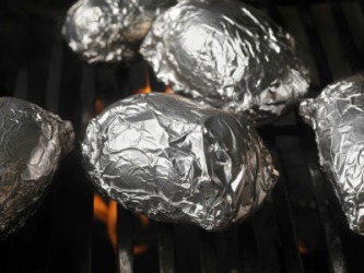 Foil wrapped food on a grill. Foil wrapped food on a grill.