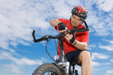 A man adjusts the handlebars on his bicycle. A man adjusts the handlebars on his bicycle.