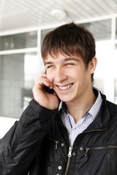 A boy gives his friend a holla on the phone. A boy gives his friend a holla on the phone.