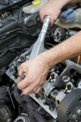 A mechanic overhauls a car. A mechanic overhauls a car.
