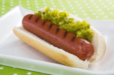 A hot dog covered with relish. A hot dog covered with relish.