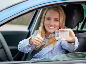 A woman proudly displaying her valid driver's license. A woman proudly displaying her valid driver's license.
