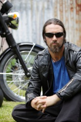 A biker sitting in front of his motorcycle. A biker sitting in front of his motorcycle.