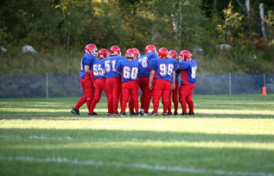 Young football players in a huddle. Young football players in a huddle.