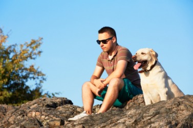A dog sits idly by his master. A dog sits idly by his master.