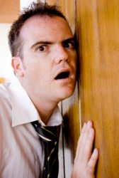 A man trying to listen through a door. A man trying to listen through a door.