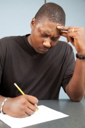 A man expressing anxiety while taking a test. A man expressing anxiety while taking a test.