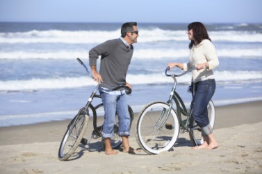 This couple have biked to the beach. This couple have biked to the beach.