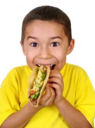 This kid is about to devour a taco. This kid is about to devour a taco.