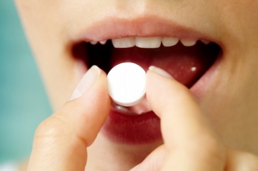A woman about to take a pill. A woman about to take a pill.