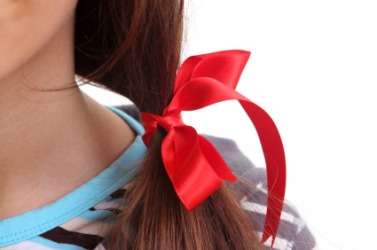 A girl with a red ribbon in her hair. A girl with a red ribbon in her hair.