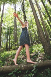 A girl walks tiptoe across a log. A girl walks tiptoe across a log.