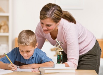 A mom helps her son with his homework assignment. A mom helps her son with his homework assignment.