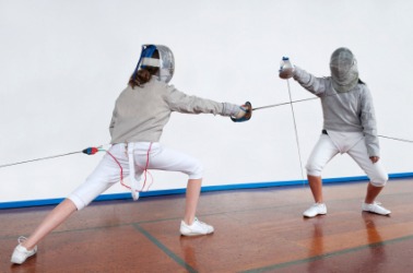 A fencer lunges at her opponent. A fencer lunges at her opponent.